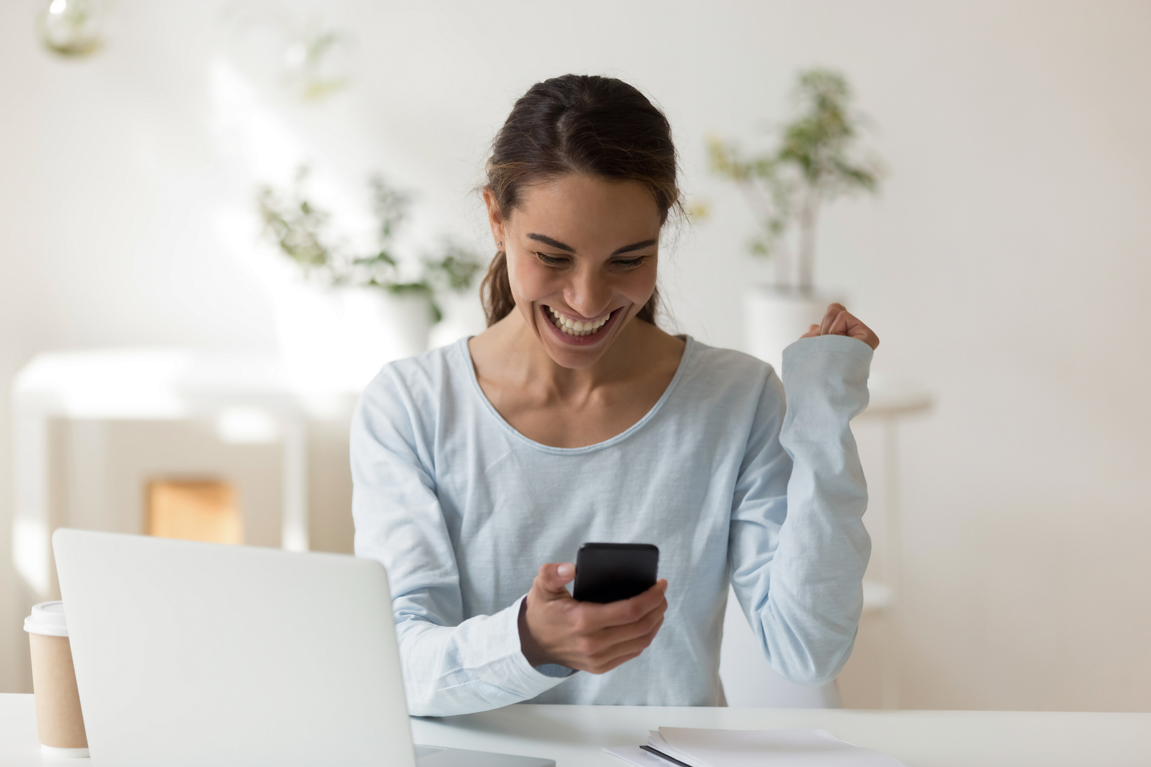 Happy woman looking at phone screen smiling